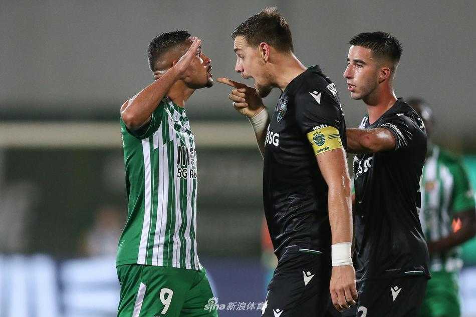 教练组成员在场边激动地向场内球员传递战术指令，他身体前倾，双手拢在嘴边，面部表情专注而急切，身后巨大的广告牌映衬出赛场紧张激烈的氛围。