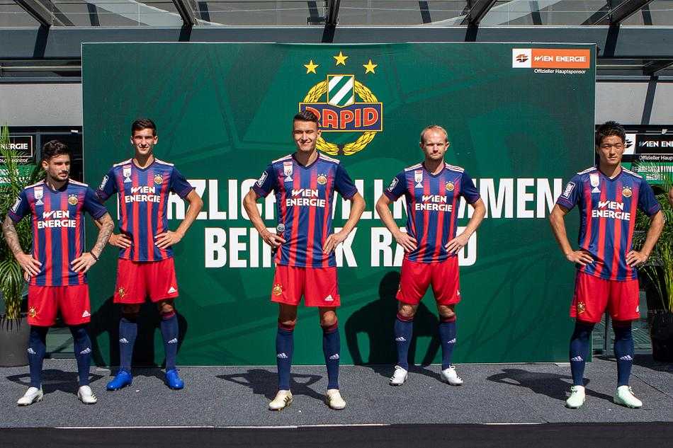 模特身穿全套新球衣在背景板前留影，简洁的白色袖子与深邃的绿色身体形成鲜明对比，胸前的队徽在灯光下格外醒目，宣告着新时代的到来。