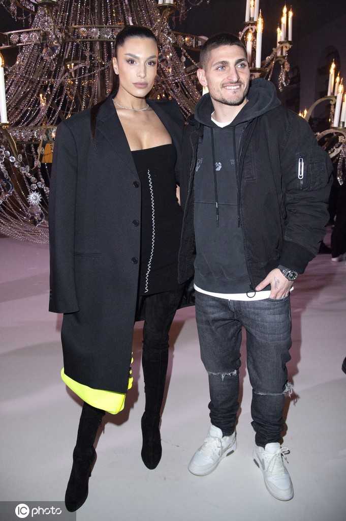 维拉蒂细心为妻子整理被微风拂乱的发丝，动作轻柔而自然，杰西卡则含笑接受这份体贴，画面定格了这个充满日常温情与宠溺的细微时刻，展现了铁汉柔情最动人的一面。