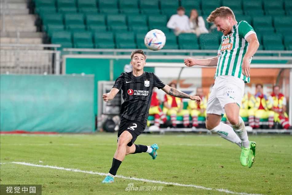 维也纳快速队前锋在对方后卫贴身干扰下，艰难护住足球，寻找传球或突破的空间