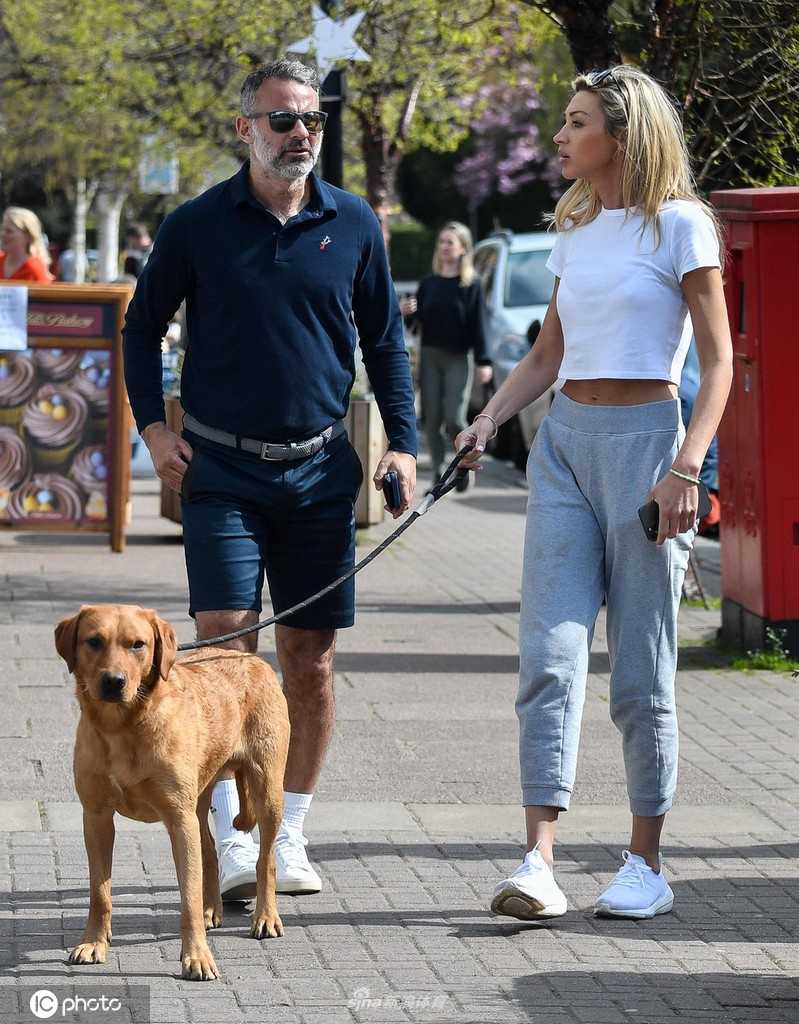 吉格斯与女友在餐厅外稍作停留，他双手插袋姿态随意，享受着无人打扰的私人时刻