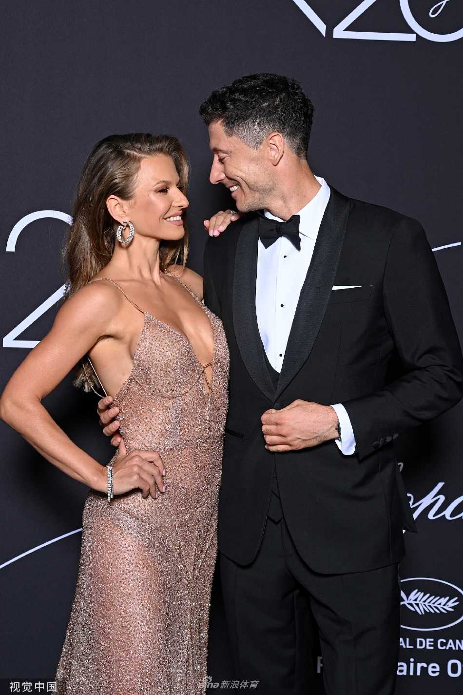 安娜笑容灿烂地看向镜头，莱万则侧首注视妻子，眼神里充满欣赏与爱恋，仿佛在向世界展示他最珍贵的宝藏。