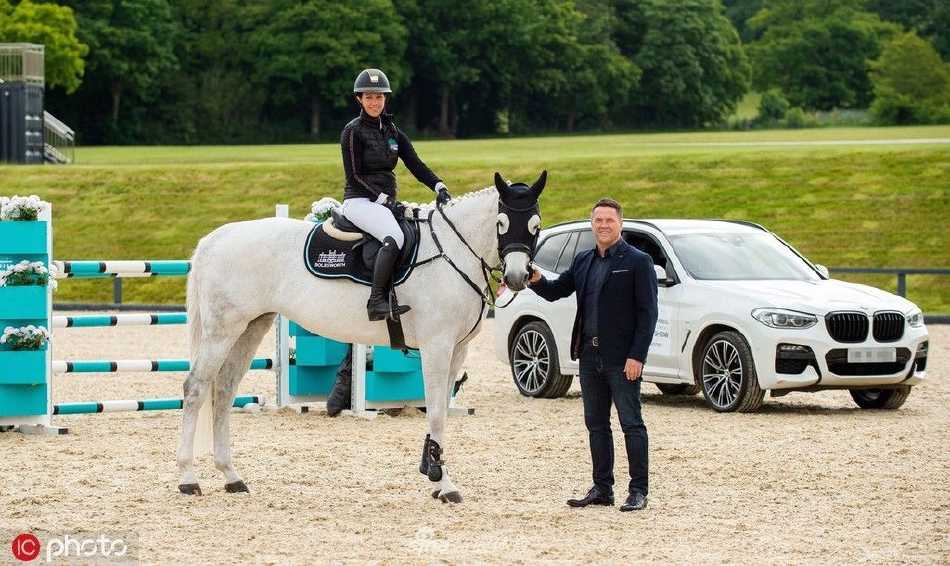 在一场正式的马术装备展示活动上，欧文作为嘉宾站立中央，与身旁身着正式骑手服的马术界人士共同面向镜头，背景是赞助商的品牌标识。