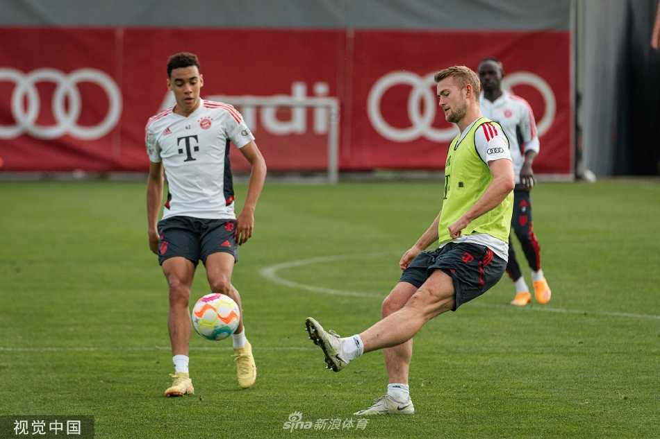 训练间隙，两名球员并肩而坐轻松交流，脸上洋溢着笑容，展现了团队内部融洽的氛围与友谊。