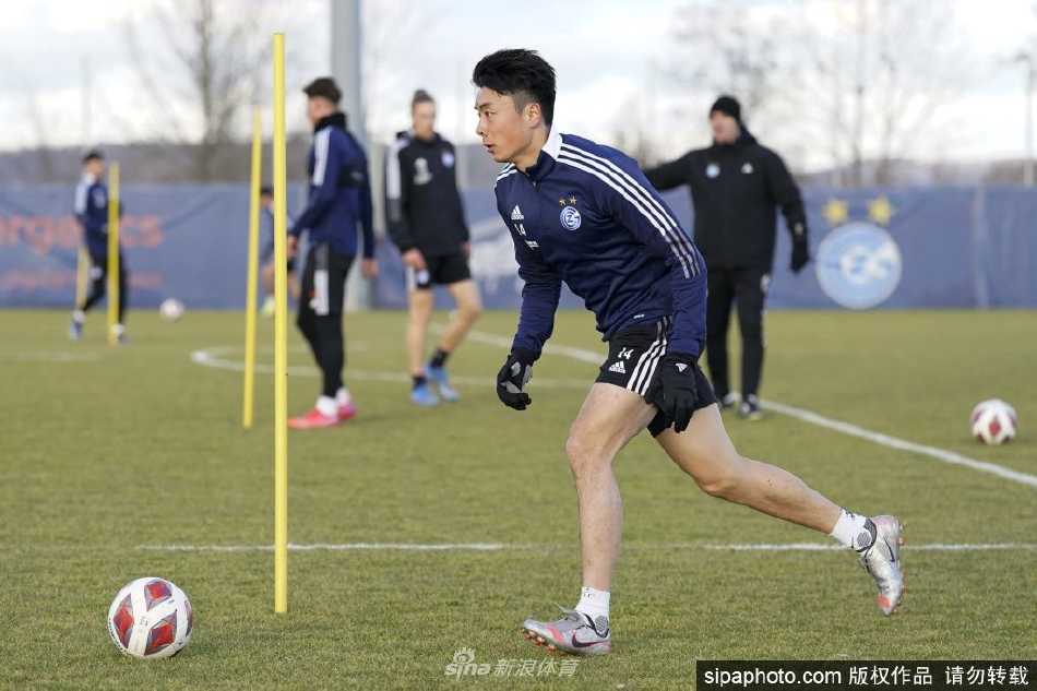 李磊在草蜢训练场上全神贯注地盘带足球，眼神坚定望向远方