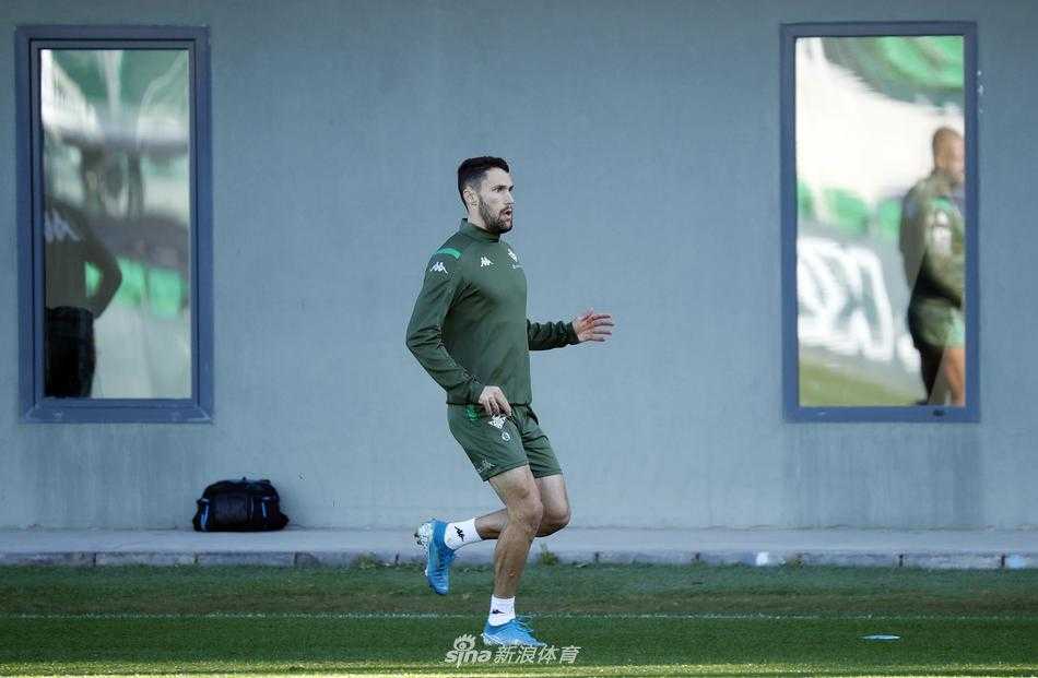 夕阳西下，训练场上的对抗赛依然激烈，一名球员高高跃起争顶头球，身体在空中形成一张拉满的弓，背景是模糊的看台和队友的身影，这张照片完美定格了备战中的铁血与柔情。