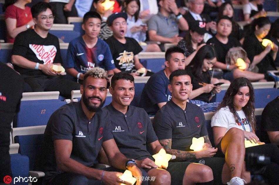 巴黎圣日耳曼队长蒂亚戈-席尔瓦正俯下身子，目光温柔地注视着身旁的自闭症儿童，他宽厚的手掌握着画笔，正耐心引导孩子在一幅色彩斑斓的画作上增添属于他们共同的想象。