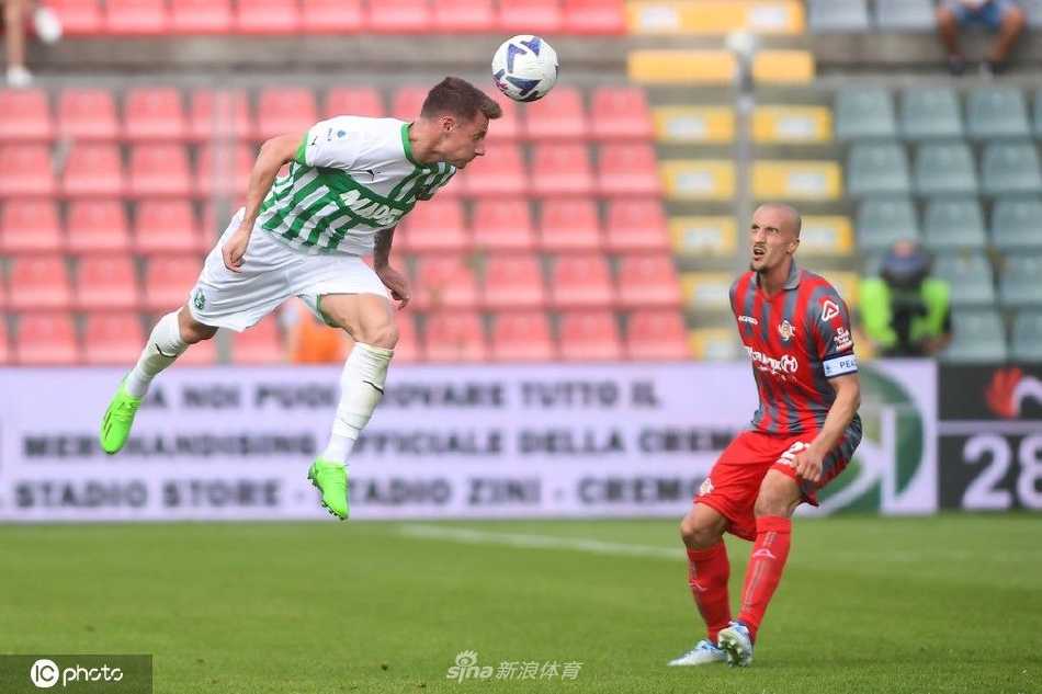 克雷莫纳队球员围住主裁判，对其一次关键的越位判罚进行解释和申诉，场上气氛紧张。